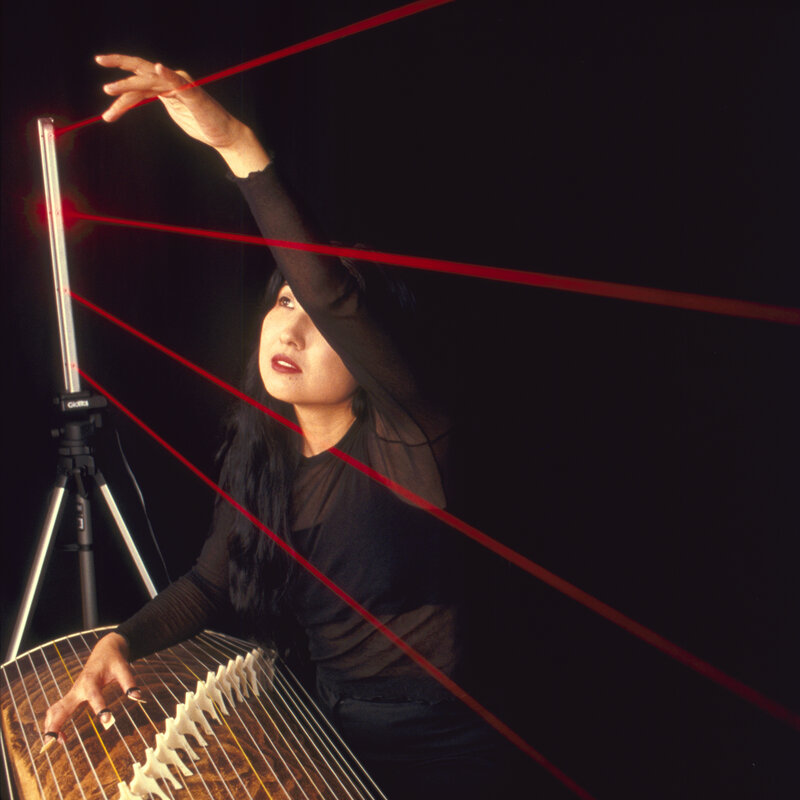 Woman playing zither with laser beams