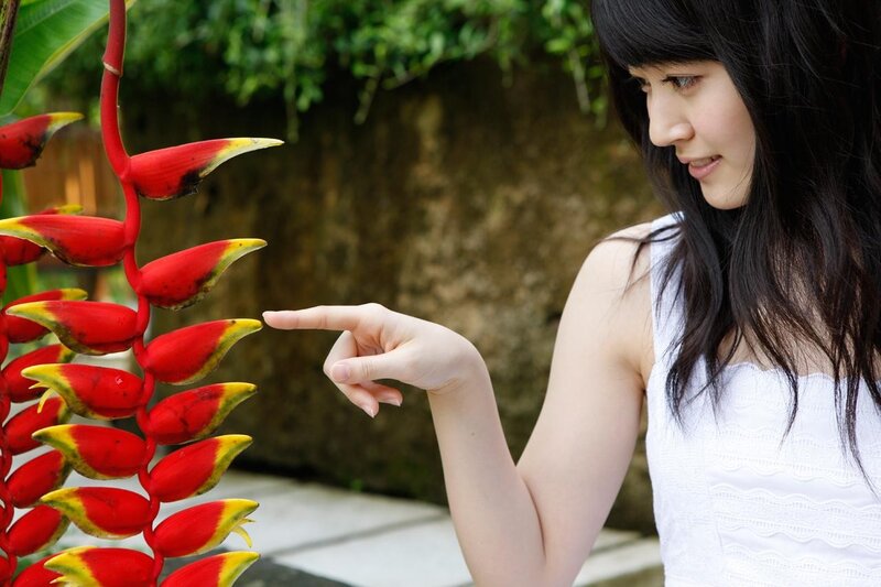 woman pointing at a flower