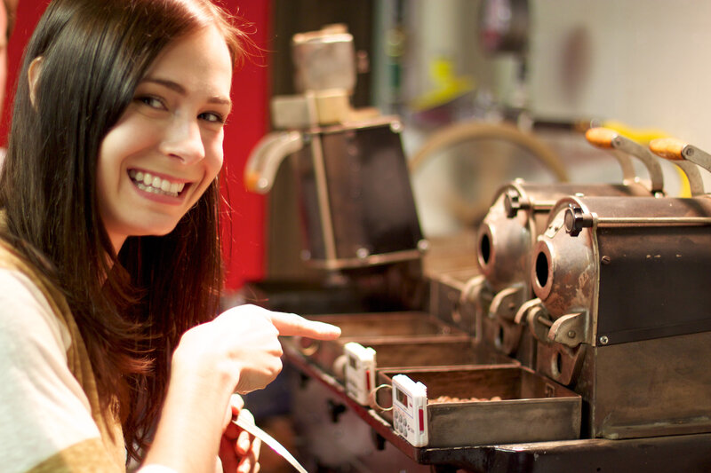 woman pointing at coffee roaster