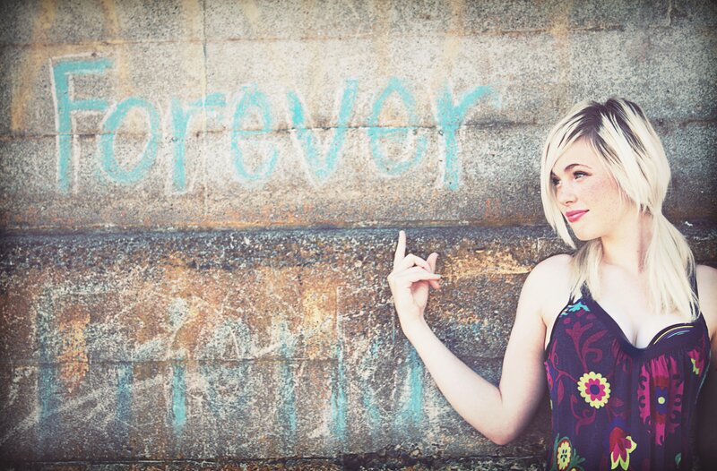 woman pointing at 'forever' graffiti