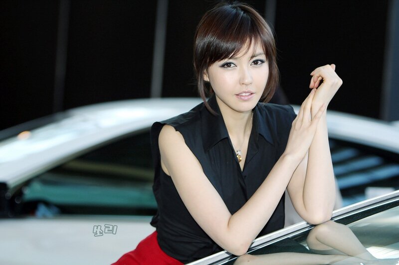 woman posing by a car