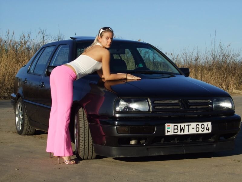 Woman posing by a car