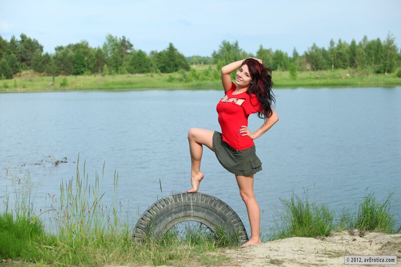 Woman posing by a lake
