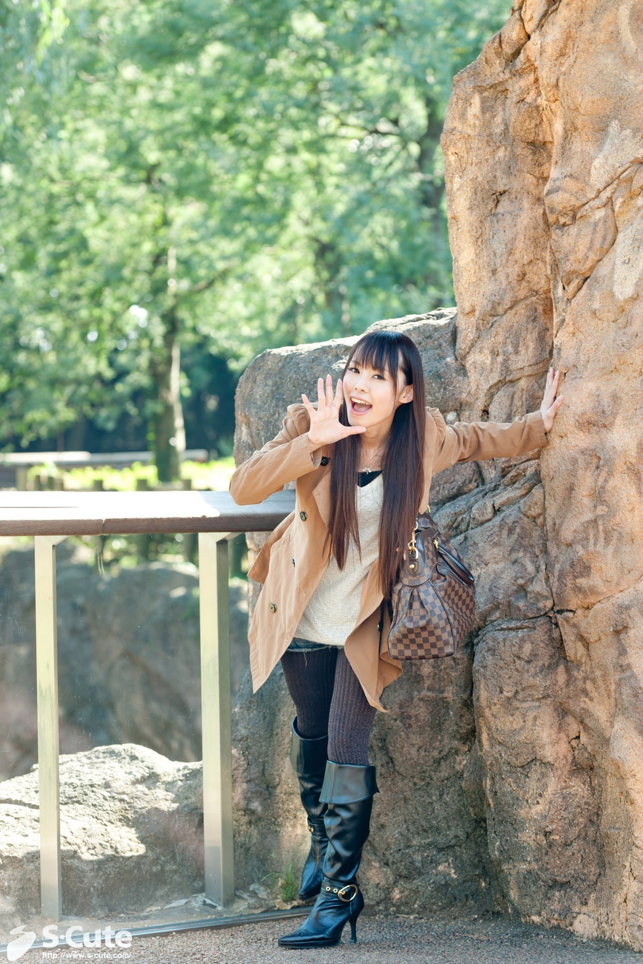 woman posing by a rock wall