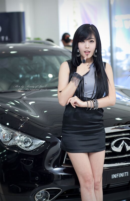 woman posing by black car