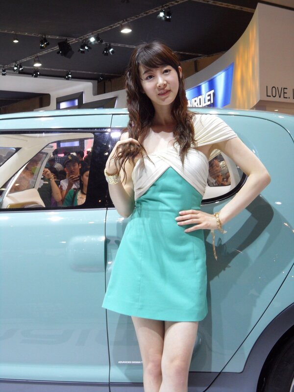 Woman posing by car at auto show