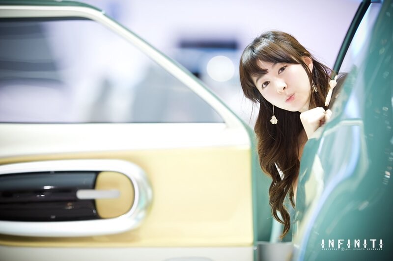 woman posing by car at show