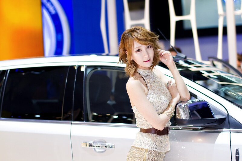 woman posing by car at show