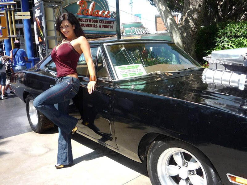 Woman posing by classic car