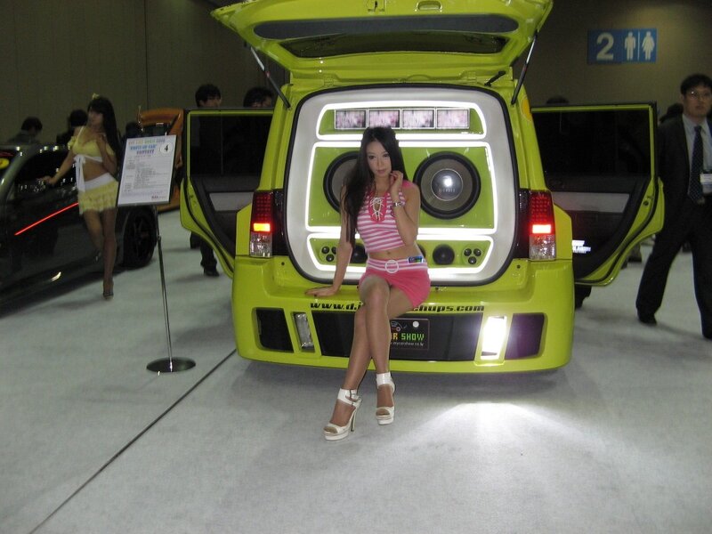 Woman posing by custom car