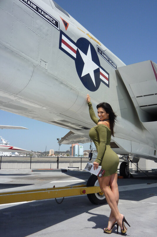 Woman posing by military aircraft