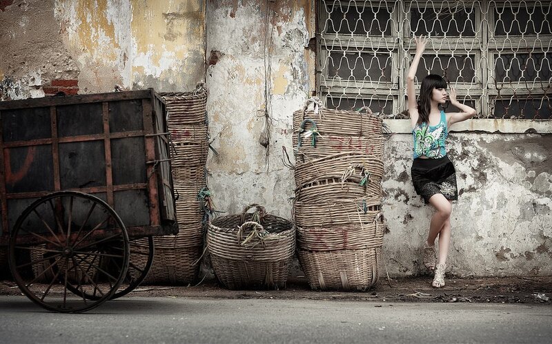 Woman posing by old baskets