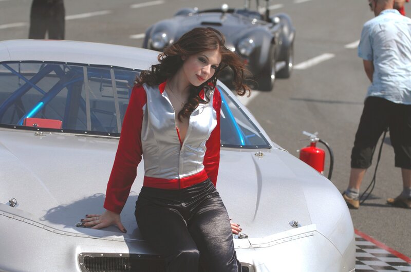 Woman posing by race car