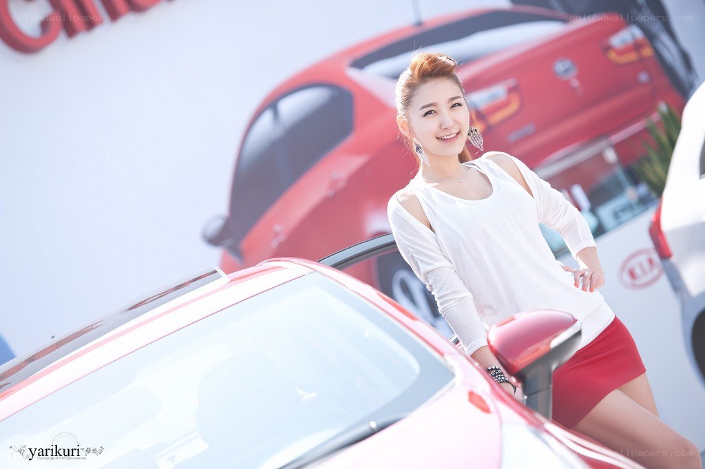 woman posing by red car