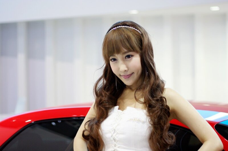 woman posing by red car