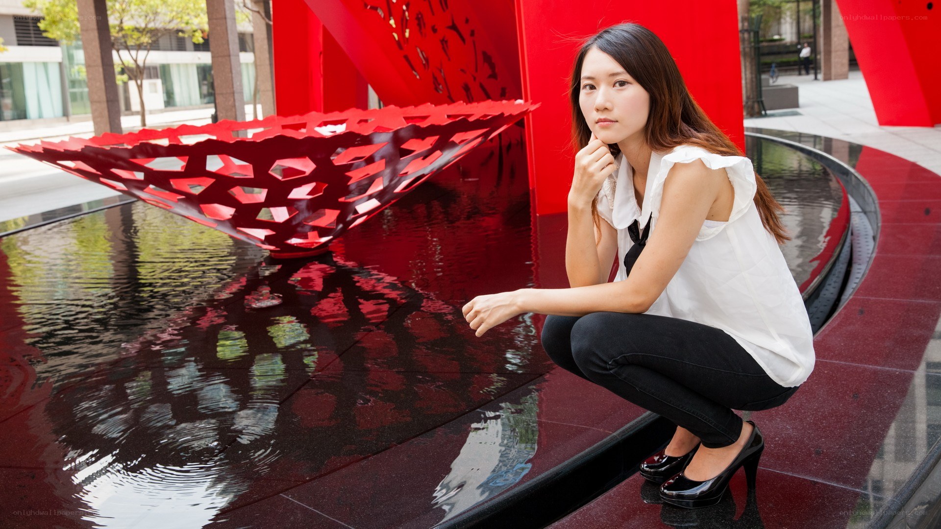 Woman posing by red sculpture