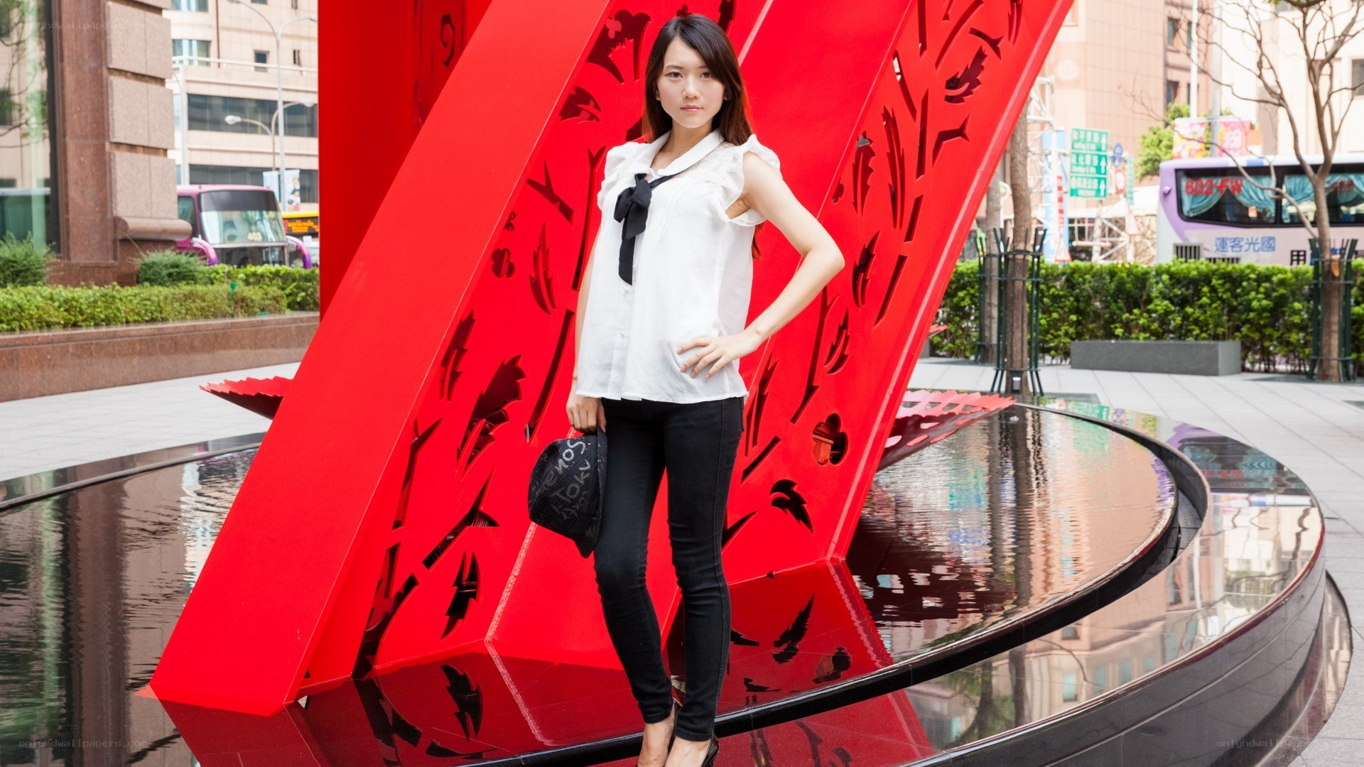 Woman posing by red sculpture