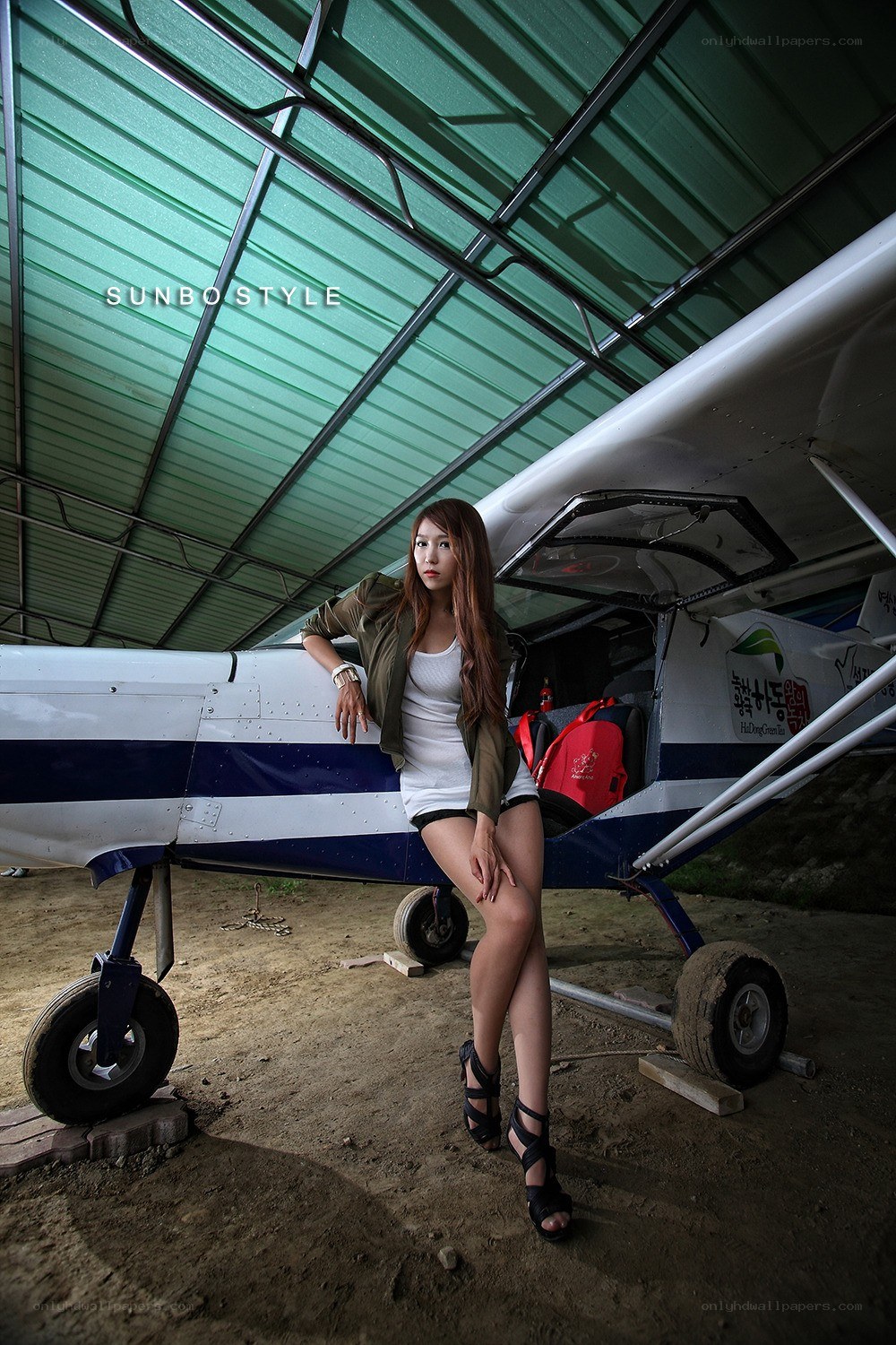 Woman posing by small airplane