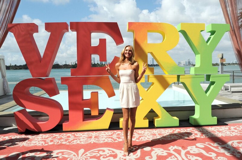 Woman posing by 'Very Sexy' sign