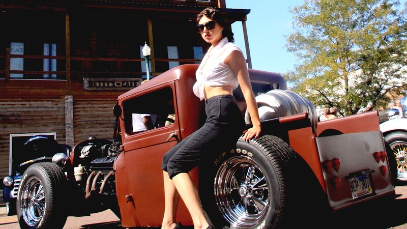 woman posing by vintage truck