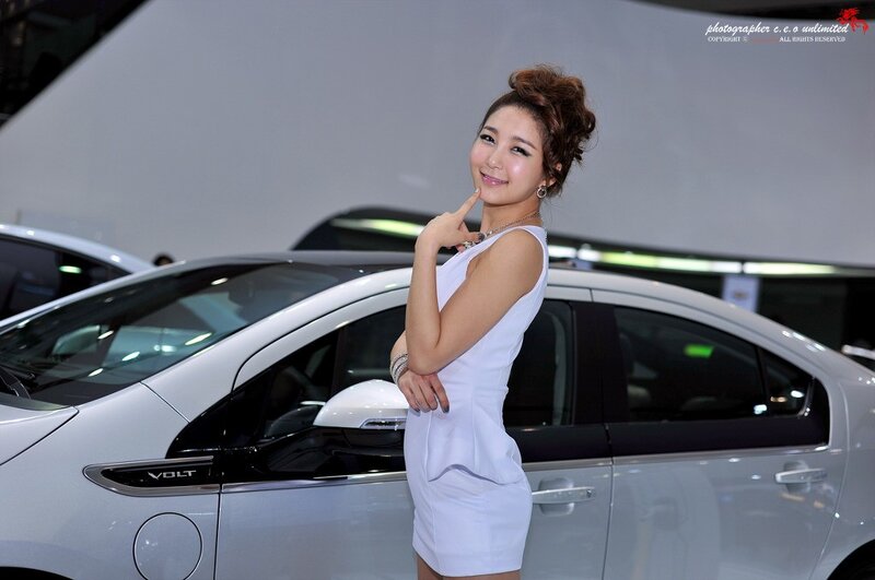 Woman posing by white car