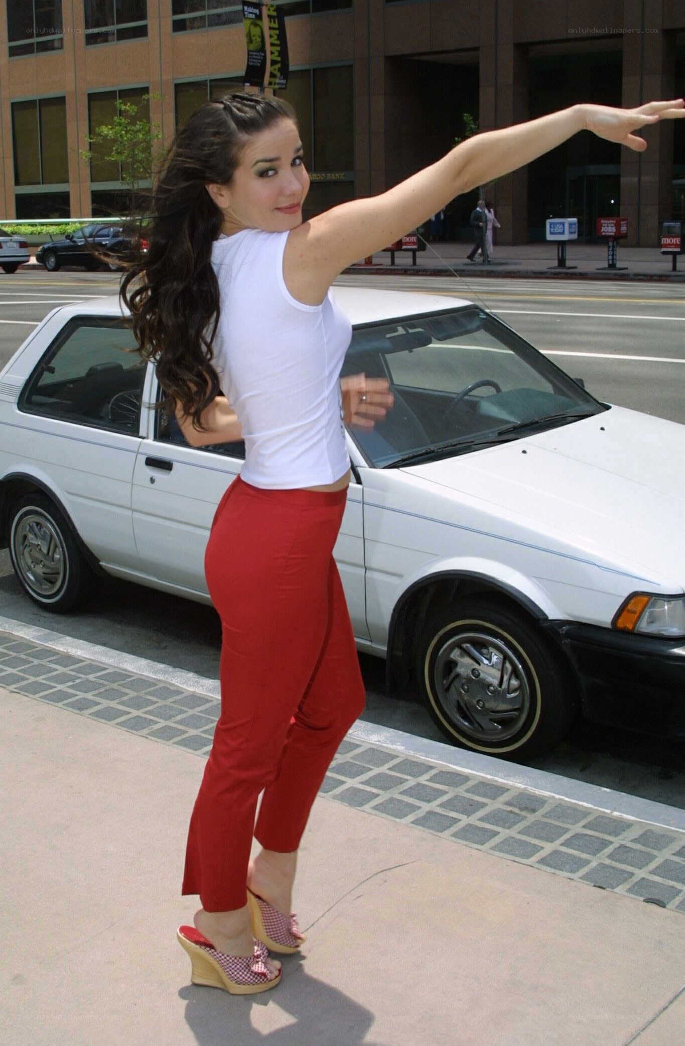 woman posing by white car