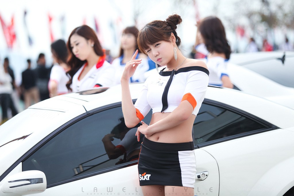 Woman posing by white car