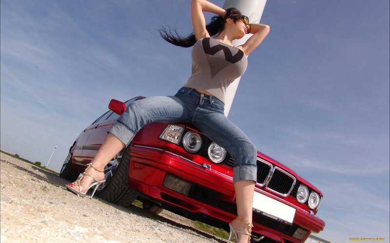 woman posing on red car