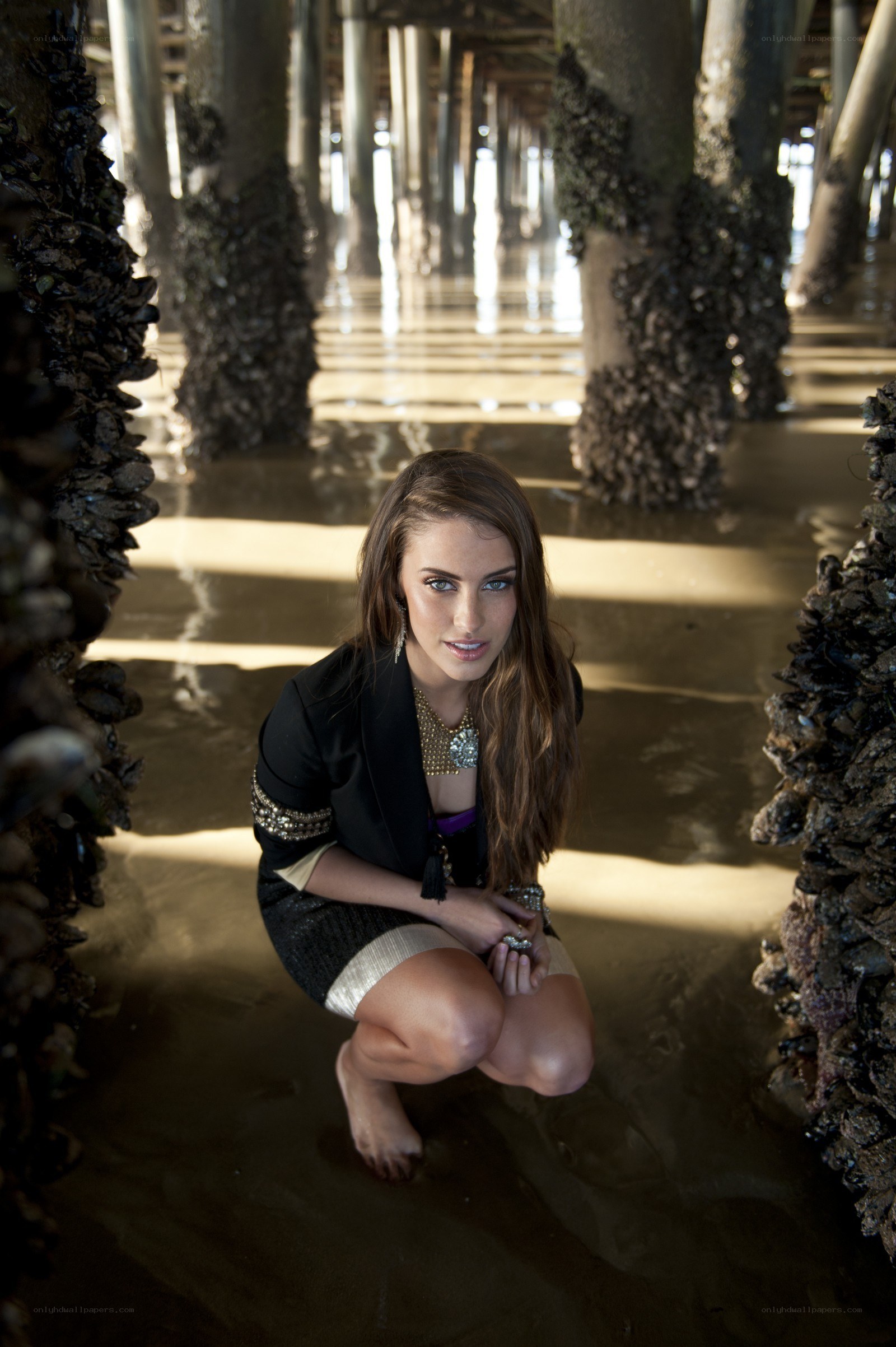 woman posing under pier
