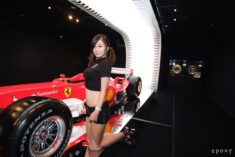 Woman posing with a Ferrari race car