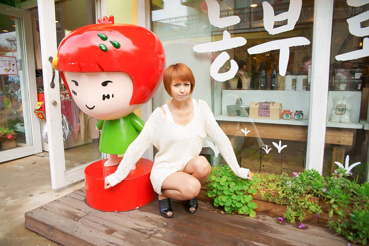 Woman posing with a strawberry statue