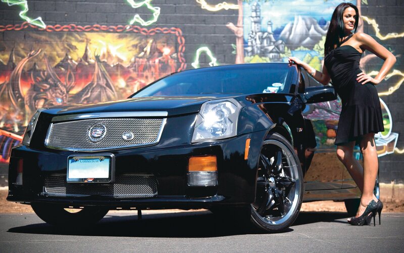 Woman posing with black Cadillac