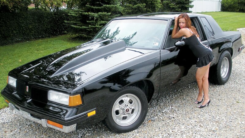 woman posing with black car
