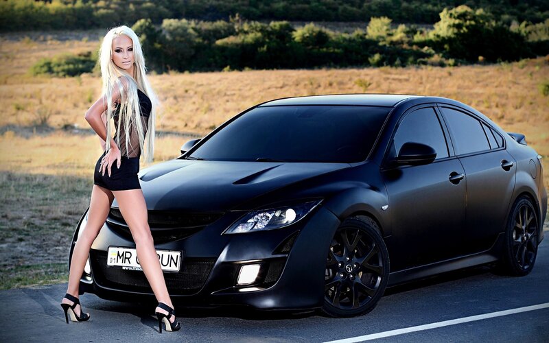 Woman posing with black car