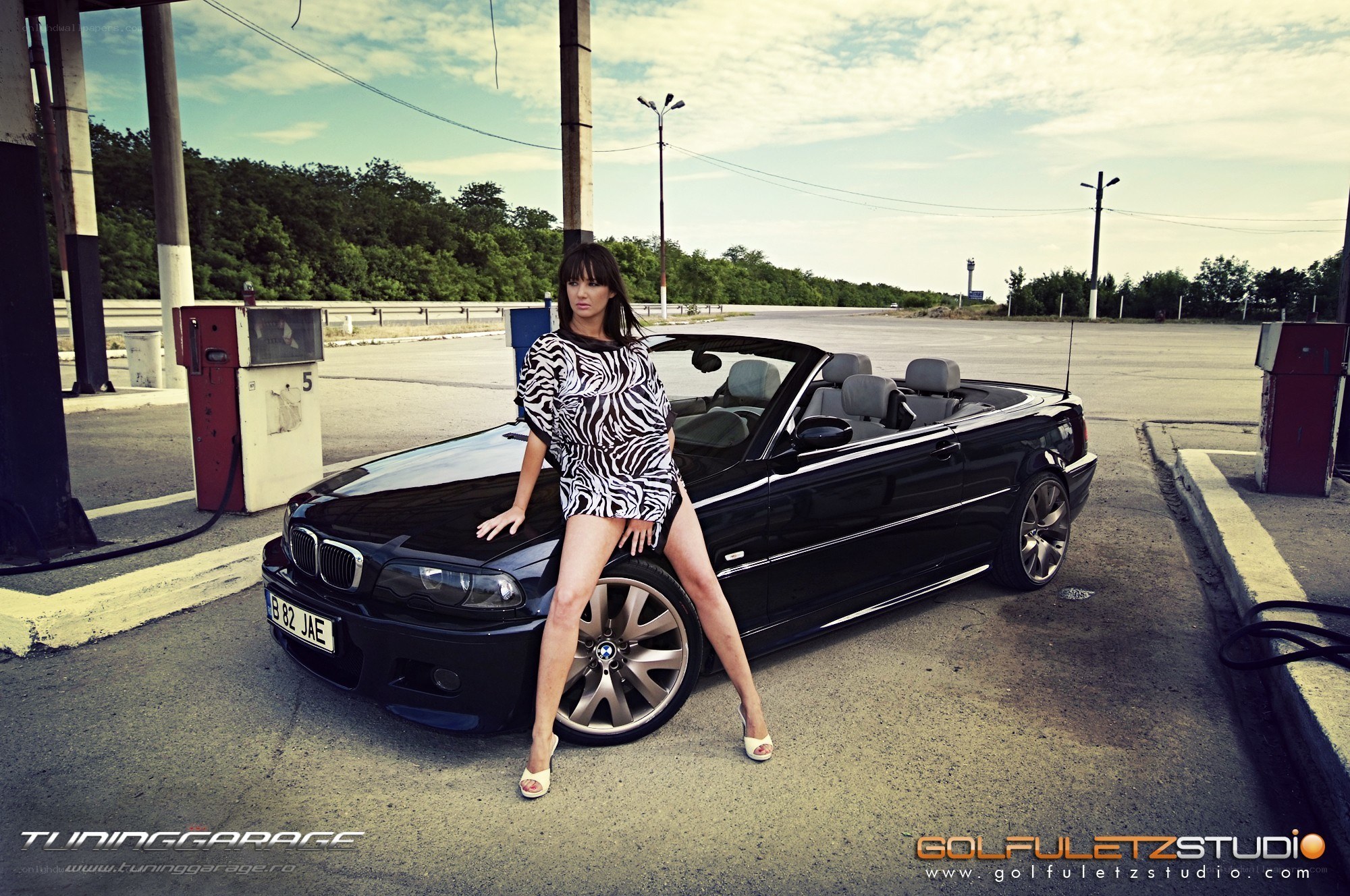woman posing with black convertible