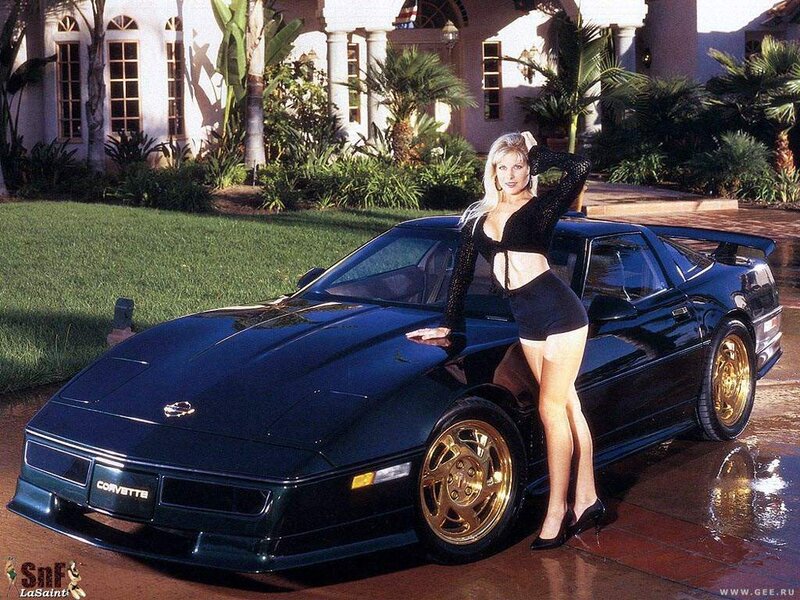 Woman posing with black Corvette