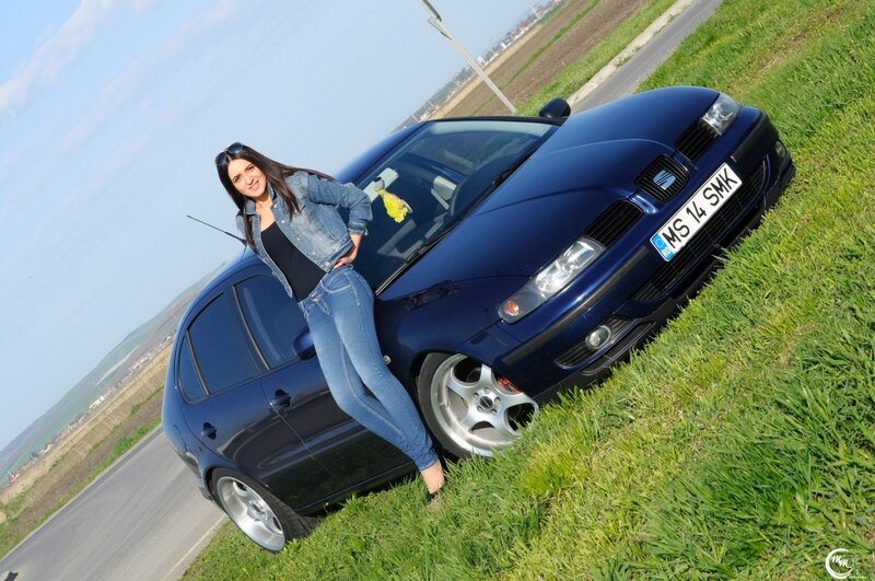 woman posing with blue car