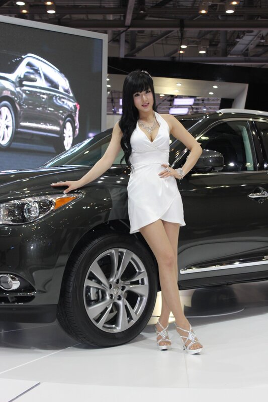 Woman posing with car at auto show