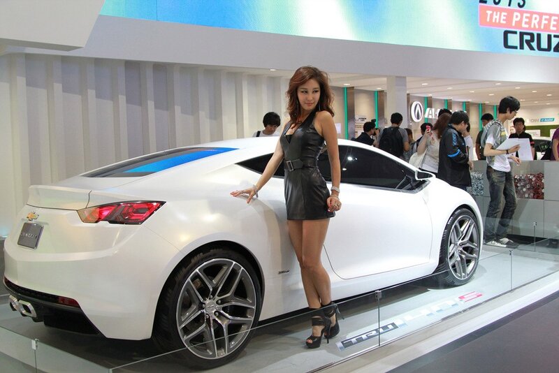 Woman Posing with Car — White, Neutral, Photograph, Show Floor, People