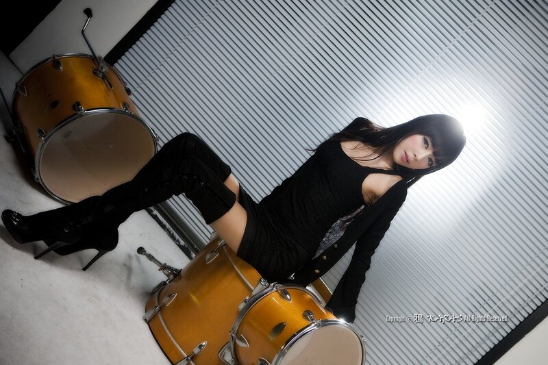 woman posing with drum set