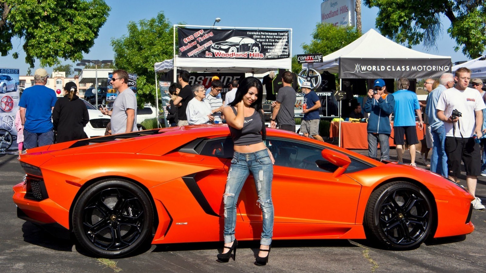 Woman posing with orange Lamborghini