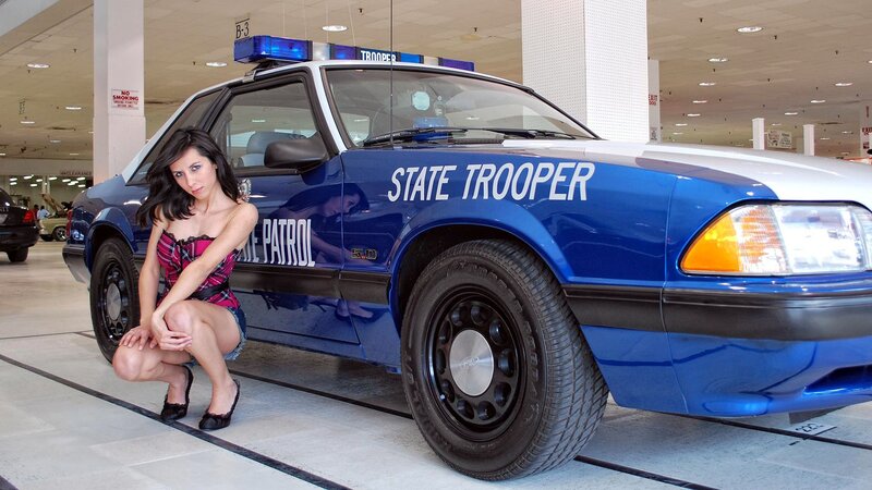 woman posing with police car