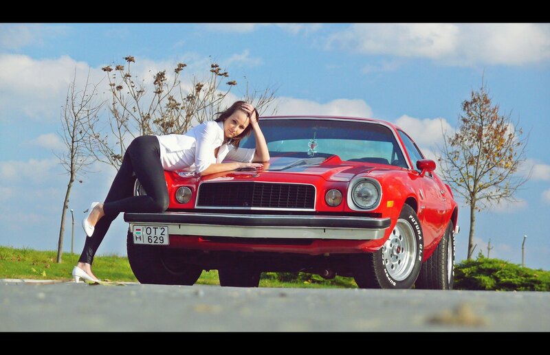 Woman posing with red muscle car