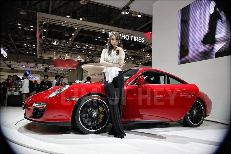 Woman posing with red Porsche