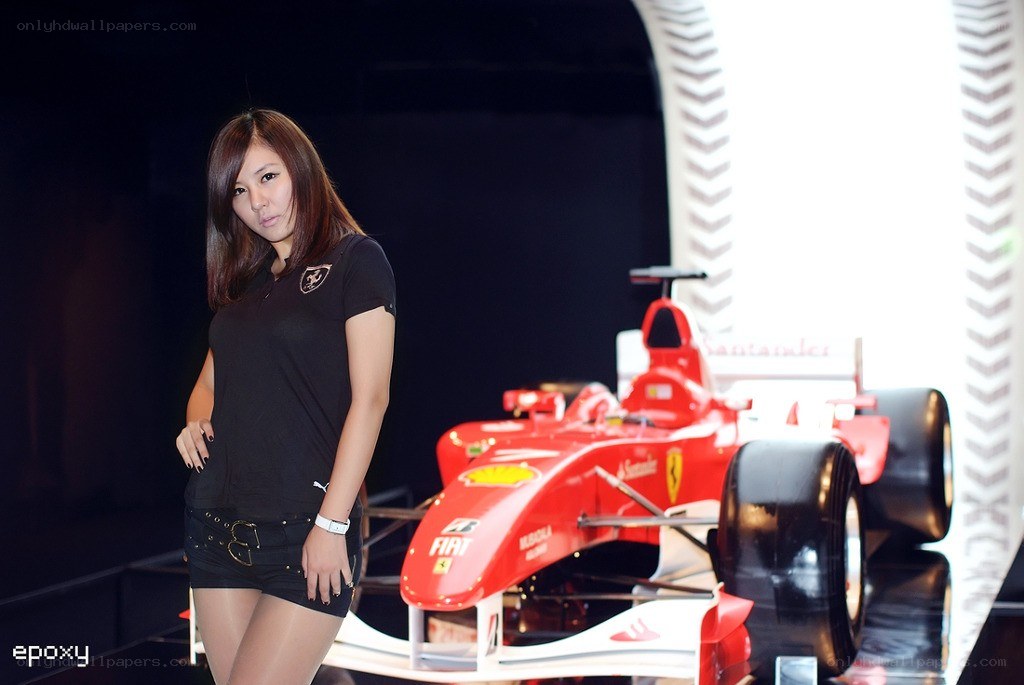 Woman posing with red race car