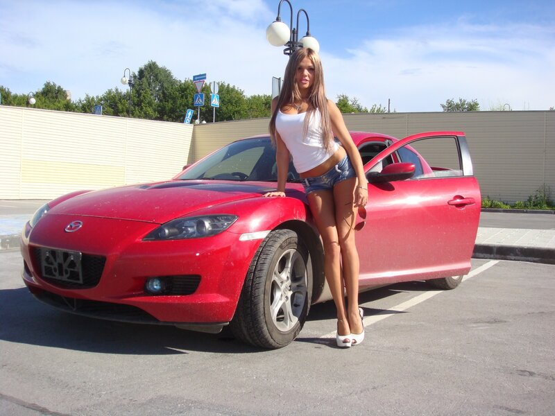 Woman posing with red sports car