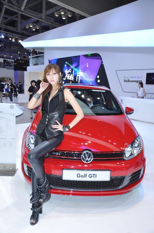 Woman posing with red Volkswagen Golf GTI