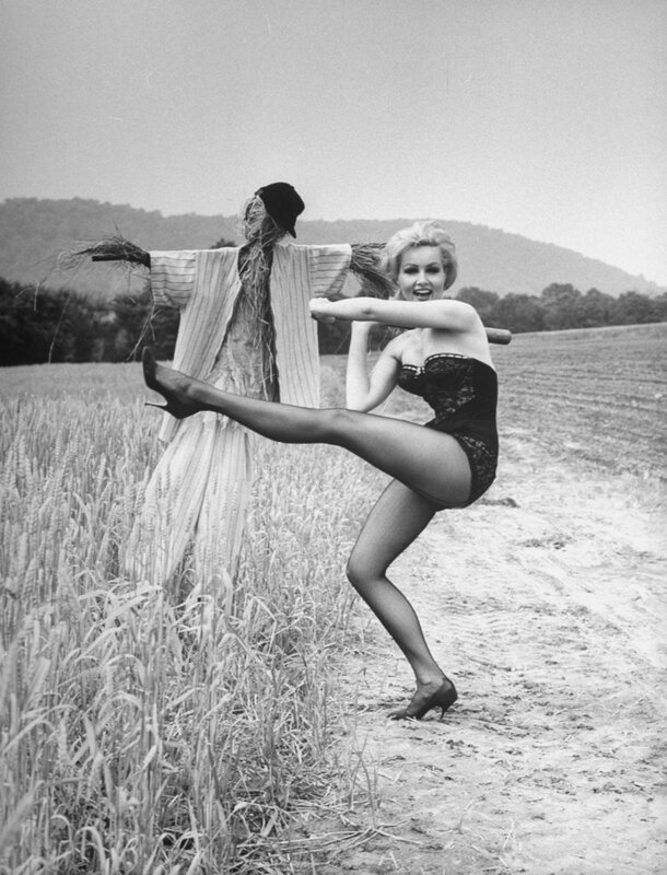 Woman posing with scarecrow