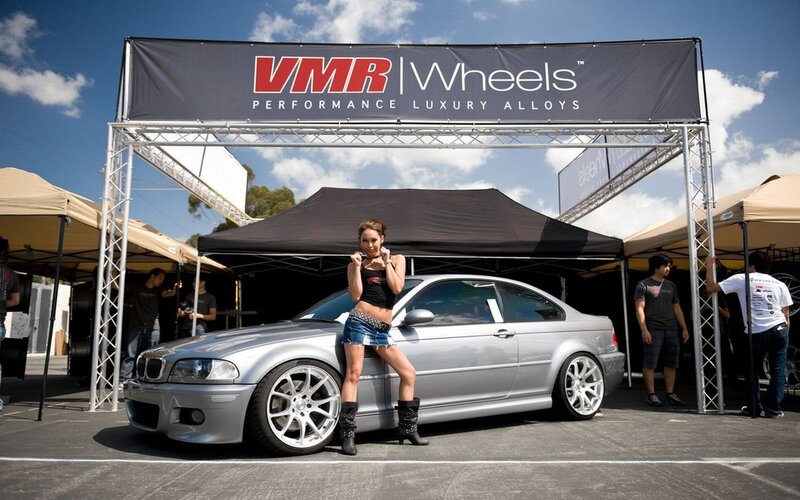 Woman posing with silver car at VMR Wheels event