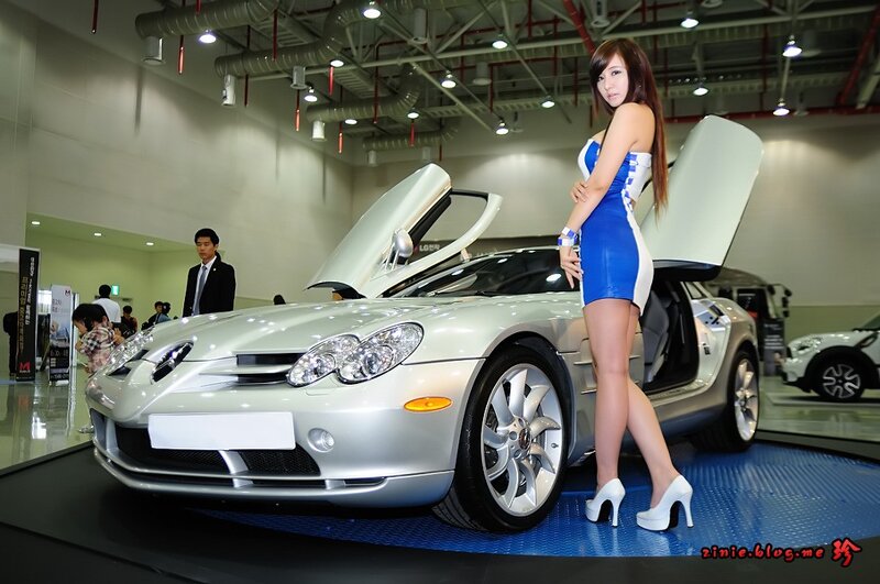 Woman posing with silver sports car